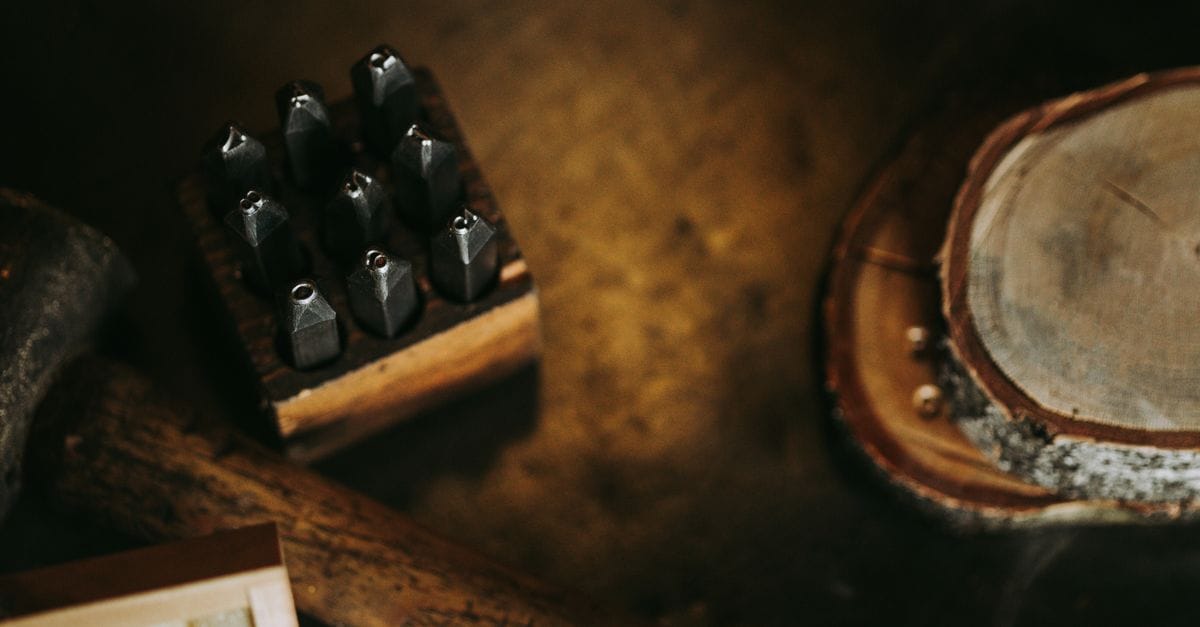 Metal letter stamping tools and hammer on a workbench