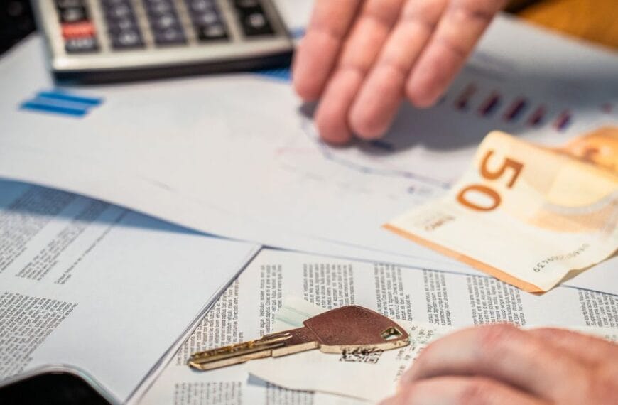 Hands reviewing financial documents beside a key