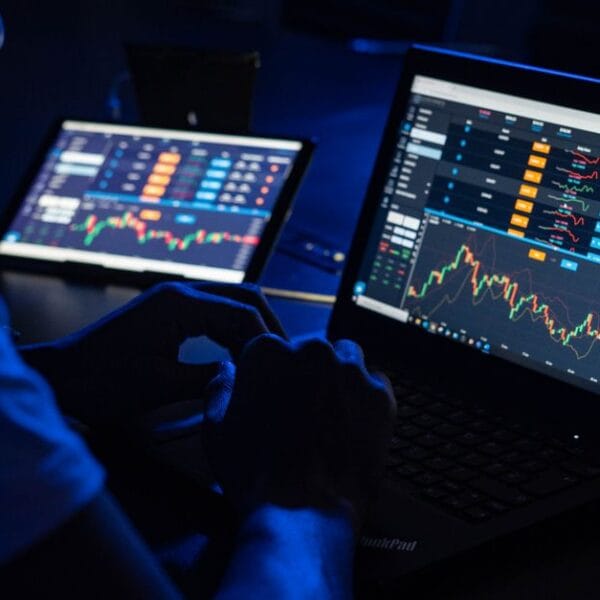Analyst reviewing financial charts across multiple screens