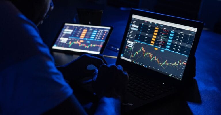 Analyst reviewing financial charts across multiple screens