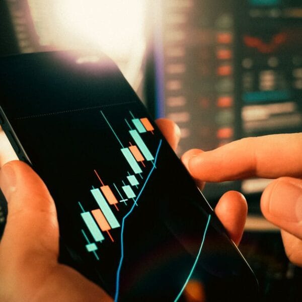Hands reviewing financial market charts on a smartphone