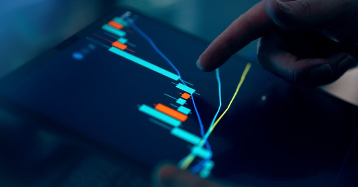 Finger inspecting financial data on a tablet chart