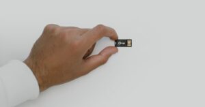 Hand holding a USB security key used to illustrate replacing compromised recovery credentials