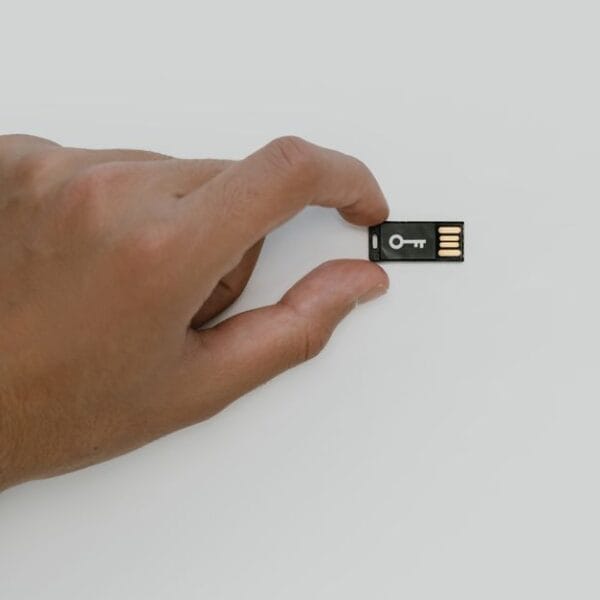 Hand holding a USB security key used to illustrate replacing compromised recovery credentials