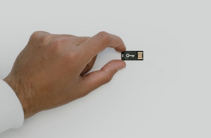 Hand holding a USB security key used to illustrate replacing compromised recovery credentials