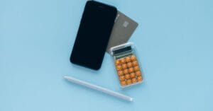 Smartphone, calculator and payment card arranged for a small financial test