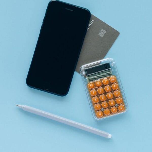 Smartphone, calculator and payment card arranged for a small financial test