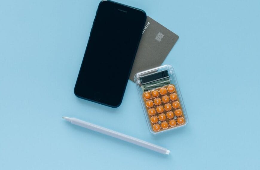 Smartphone, calculator and payment card arranged for a small financial test