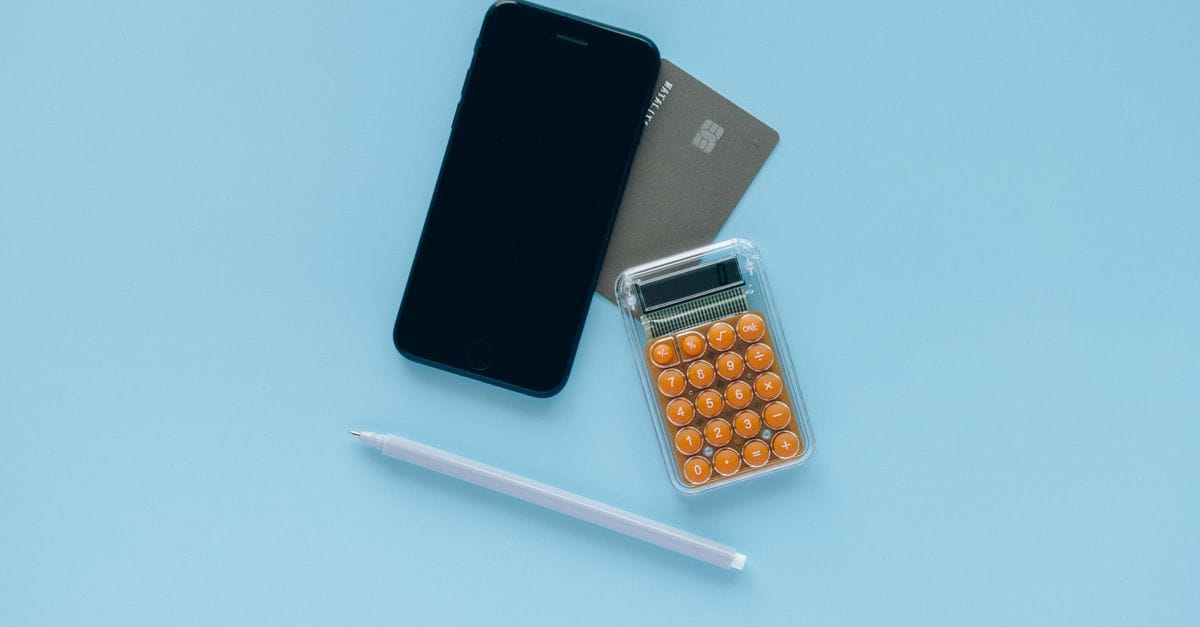 Smartphone, calculator and payment card arranged for a small financial test