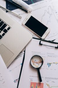 Financial records, smartphone and magnifying glass used to examine what portfolio trackers know and miss