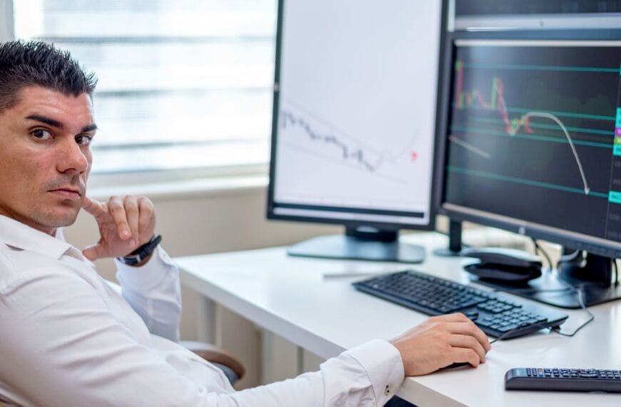 Analyst examining market data across several computer screens