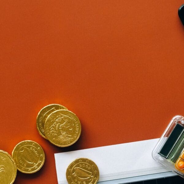 Coins, calculator and financial charts used for opportunity-cost analysis