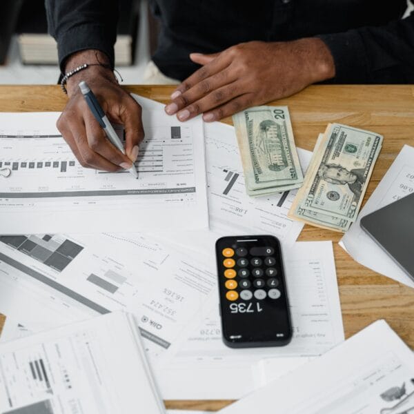 Accountant working through financial reports with a calculator and laptop for a crypto tax software review