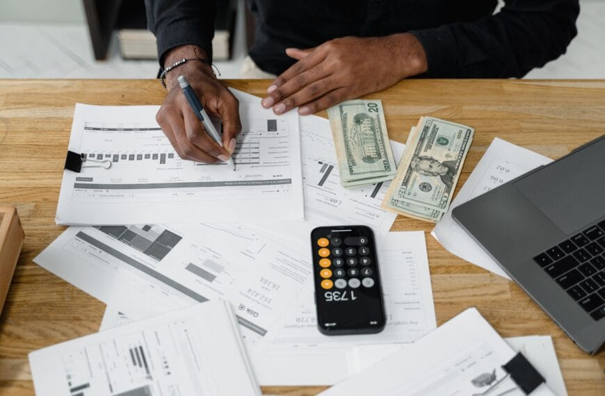 Accountant working through financial reports with a calculator and laptop for a crypto tax software review