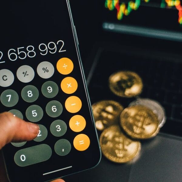 Smartphone and laptop beside Bitcoin objects during a transfer workflow