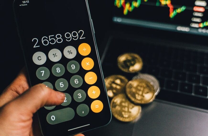 Smartphone and laptop beside Bitcoin objects during a transfer workflow