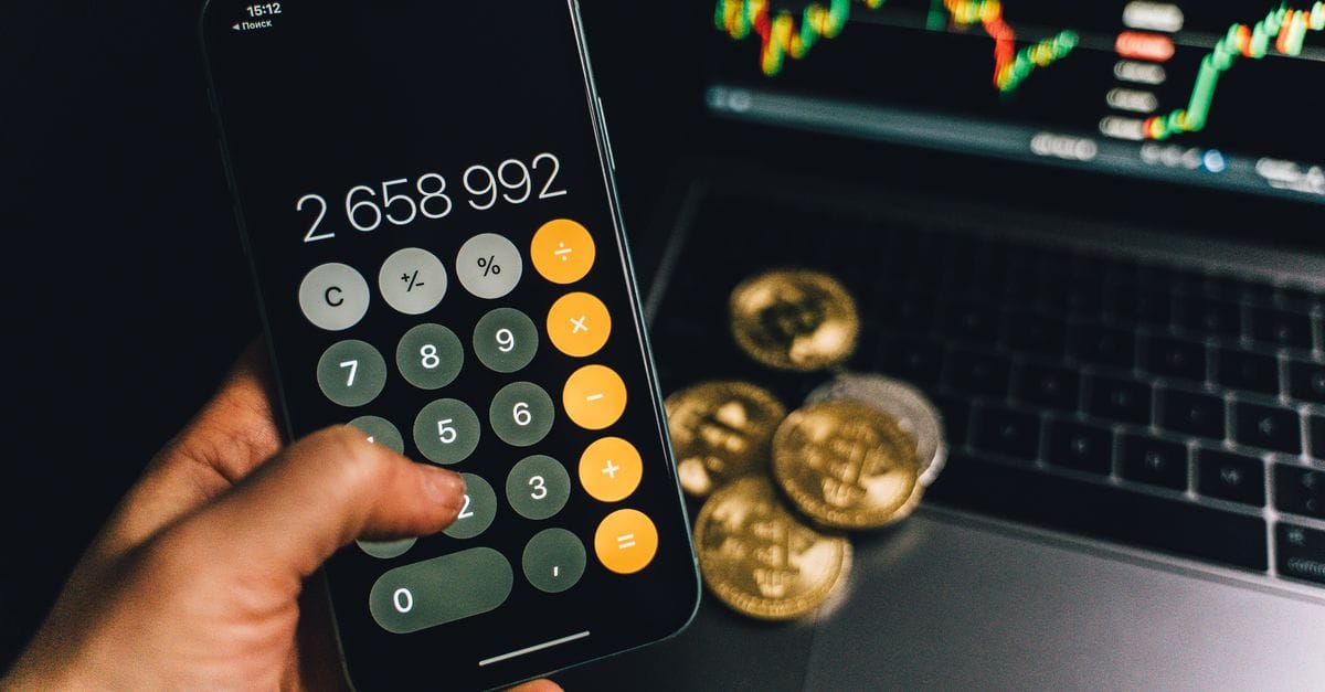 Smartphone and laptop beside Bitcoin objects during a transfer workflow