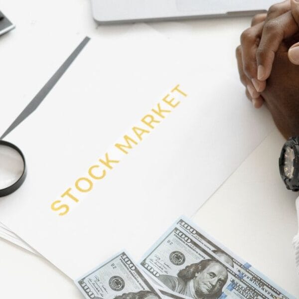 Hands reviewing financial market documents with calculator, cash and magnifying glass for crypto risk assessment