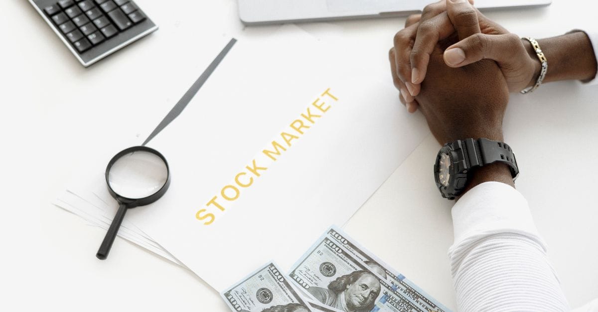 Hands reviewing financial market documents with calculator, cash and magnifying glass for crypto risk assessment