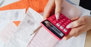 Person using a calculator among receipts and financial documents