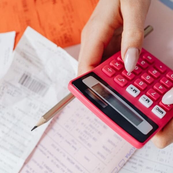 Person using a calculator among receipts and financial documents