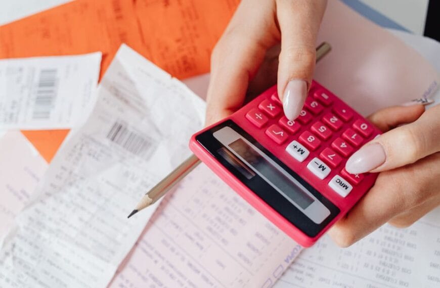 Person using a calculator among receipts and financial documents