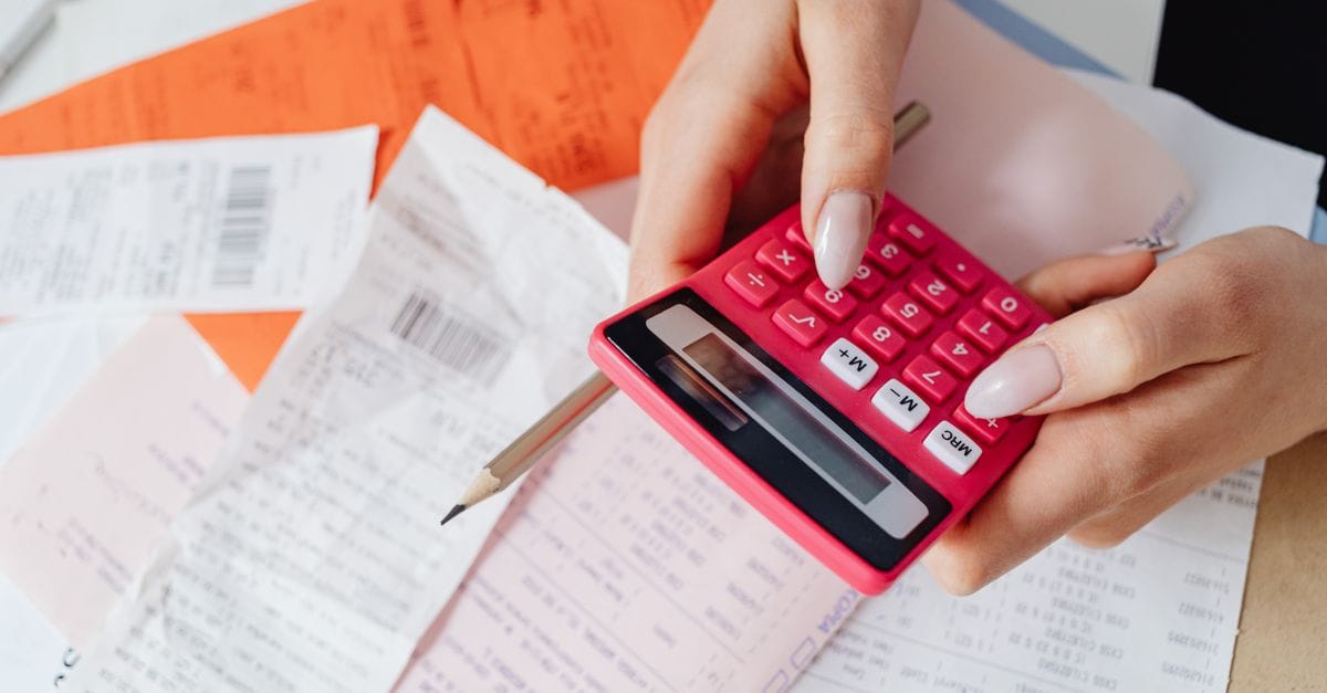 Person using a calculator among receipts and financial documents