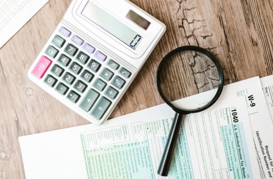Financial documents, calculator and magnifying glass used for a historical trade investigation