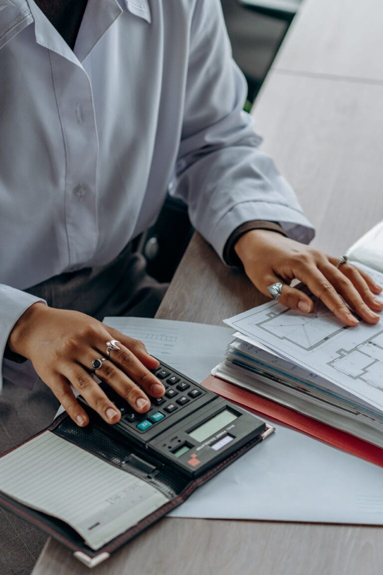 Accountant reviewing financial documents with a calculator to reconstruct missing crypto cost basis records