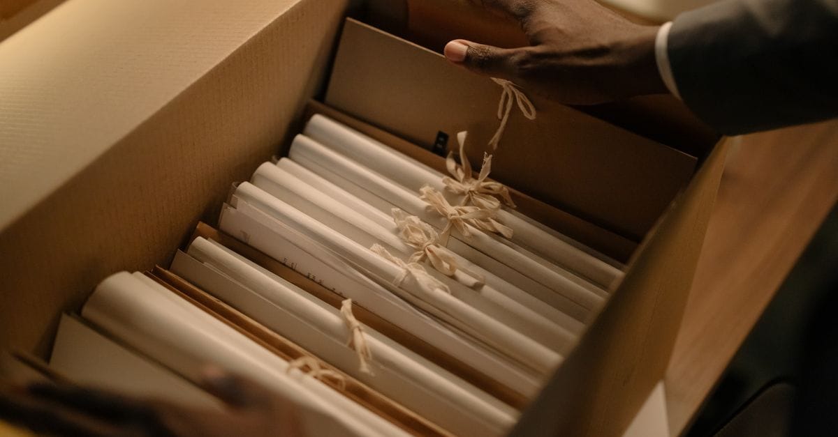 Hands organizing file folders in a records box during document review