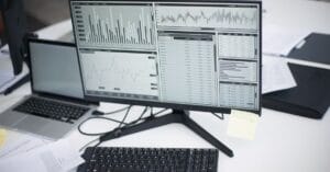 Multiple computers displaying analytical graphs in a research workspace