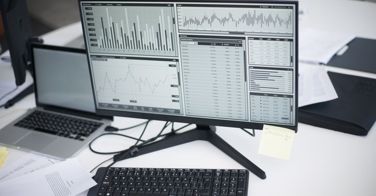 Multiple computers displaying analytical graphs in a research workspace